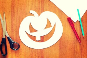 Halloween pumpkin cut out of paper lying on the table